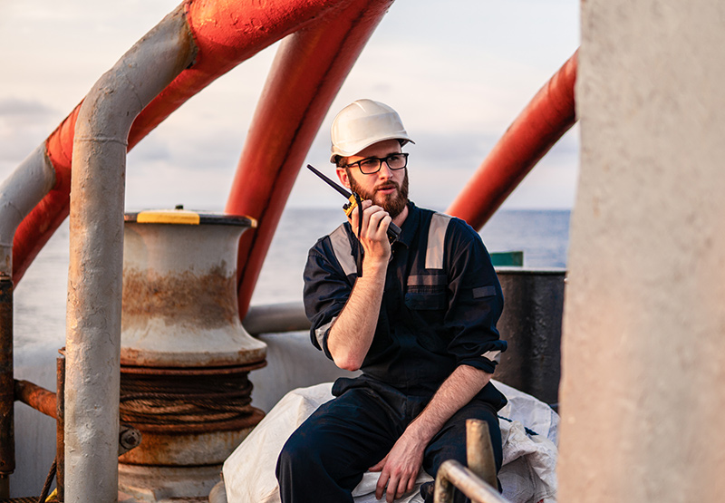 man-in-hard-hat-uses-radio-at-sea-2026-01-08-05-31-11-utc man-in-hard-hat-uses-radio-at-sea-2026-01-08-05-31-11-utc